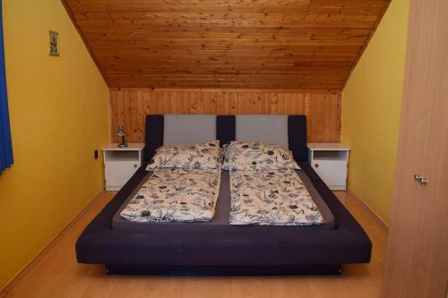 een bed in een kamer met gele muren bij Schmidt nyaraló Fonyód in Fonyód