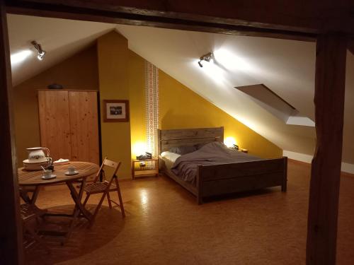 デュルビュイにあるAux Saveurs d'Enneilleのベッドルーム(ベッド1台、テーブル付)