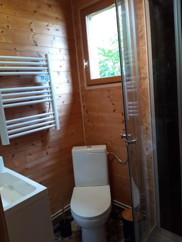 une salle de bain avec toilettes, lavabo et fenêtre dans l'établissement Chalet chaleureux avec parking garage motos, vélos, à La Chapelle-aux-Chasses