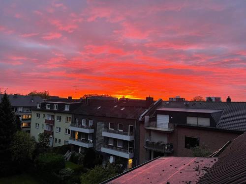 una puesta de sol en una ciudad con casas y edificios en gemütliche Ferienwohnung, en Düsseldorf