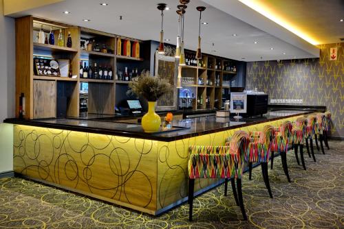 a bar in a restaurant with a yellow vase on the counter at Fountains Hotel in Cape Town