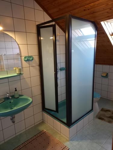 a bathroom with a green sink and a mirror at Hévízi fecskefészek in Hévíz