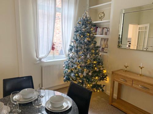 a christmas tree in the corner of a room with a table at Park Crescent Lodge - Quaint Victorian Home With Free Parking in York