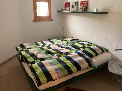 a bed with a colorful blanket on it in a room at Casa Selva 2000 Fl Whg Nr 2 in Lenzerheide