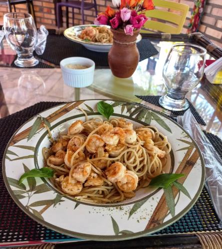 a plate of shrimp pasta on a table at Hotel Enseada Maracajaú in Maracajaú