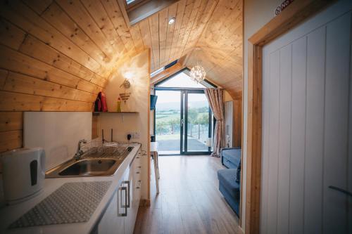 a kitchen with a sink and a wooden ceiling at Carntogher Cabins in Derry Londonderry