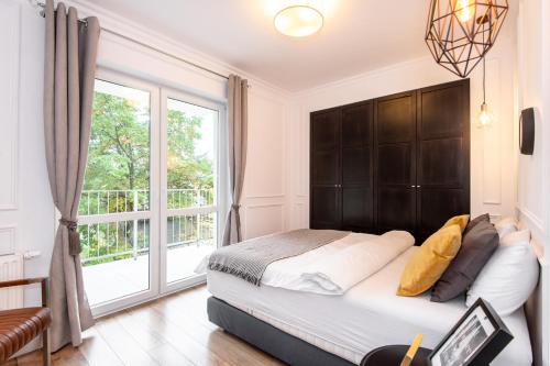 Un dormitorio con una cama y una ventana grande. en Super-Apartamenty Andersia VIP II, en Poznan