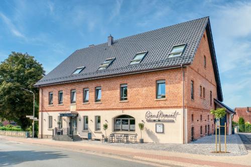 a large red brick building with a black roof at One Moment Boardinghouse - Apartment Harmony in Porta Westfalica