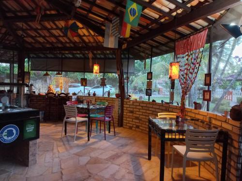 a restaurant with tables and chairs in a room at Hotel Enseada Maracajaú in Maracajaú