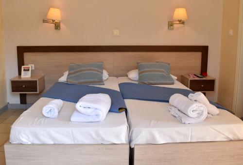 sypialnia z 2 łóżkami i ręcznikami w obiekcie Vassilis Studio's w mieście Perivólion
