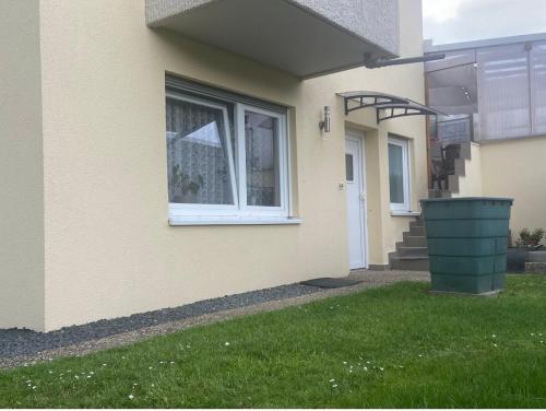 a house with a window and a green trash can at Olgas Ferienwohnung Saarburg Bahnhofstraße 13G in Saarburg