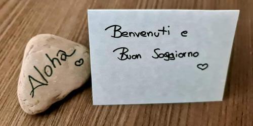 a cookie next to a sign with a note at Garda Lake Aloha Apartments in Nago-Torbole