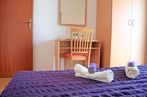 a bedroom with two stuffed animals in towels on a bed at Apartments Villa Zvonimir in Slatine