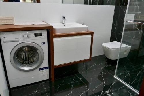 a bathroom with a washing machine and a sink at Branickiego 23 Apartment close to Medicover and Paley in Warsaw