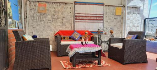 Habitación con sillas de mimbre, cama y mesa en Chikan Hoteles en Arequipa