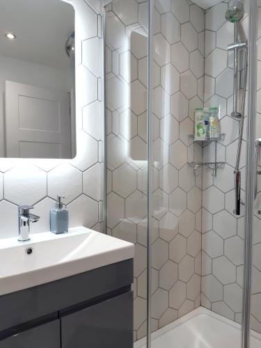 a white bathroom with a sink and a shower at Chalet 174 Glan Gwna Park Caernarfon in Caeathro