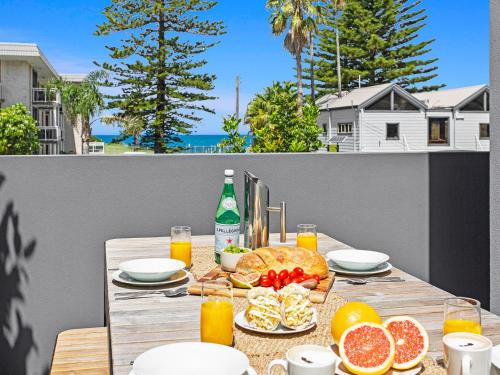 a table with food and drinks on a balcony at Bikinis and Martinis in Kiama