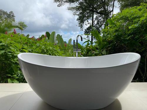 a large white bath tub sitting in a garden at Oxygen Jungle Villas & Spa in Uvita