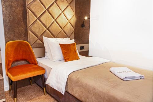a hotel room with a bed and a chair at Hotel Ub Aqua Park in Ub