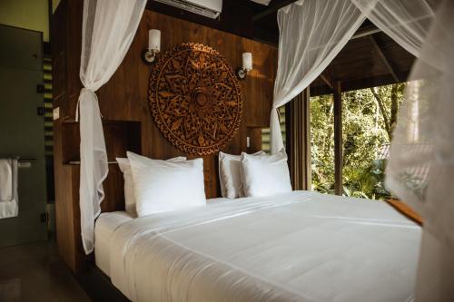 a bedroom with a large white bed with a window at Oxygen Jungle Villas & Spa in Uvita