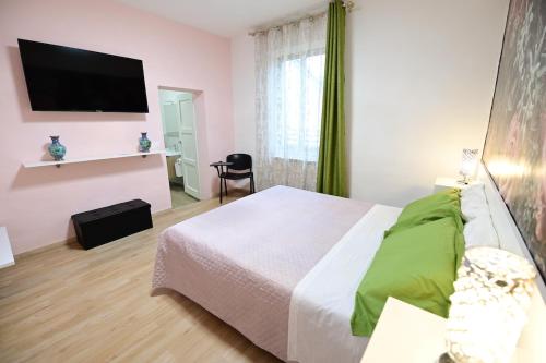 a bedroom with a bed and a flat screen tv at La casa di Odessa in Arcevia