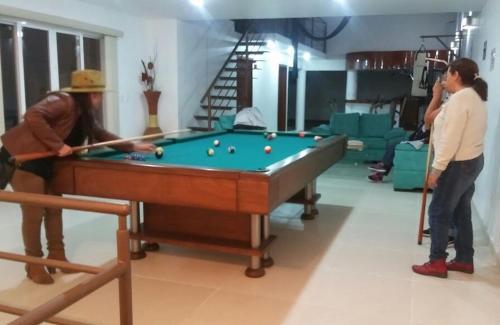two people playing a game of pool in a room at La Aurora Hotel Like Home in Huamantla