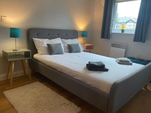 a bedroom with a large white bed with a window at Lime Tree Apartment in Coventry