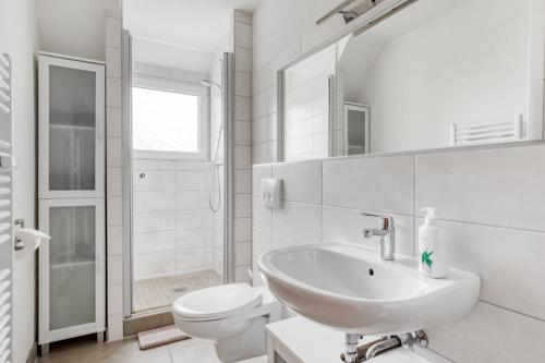a white bathroom with a sink and a toilet at Gutmensch Oberhausen 4 Schlafzimmer in Oberhausen