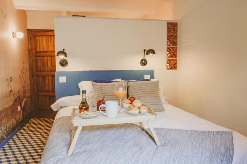 a bed with a tray of fruit and drinks on it at La Corredera in Candeleda