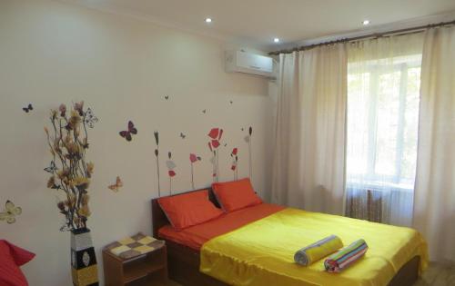 een slaapkamer met een bed met rode en gele lakens bij Best-BishkekCity Apartment 3 in Bisjkek