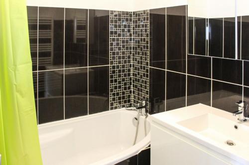 une salle de bain avec une baignoire blanche et un lavabo dans l'établissement Miracle Morning, à La Grande Motte