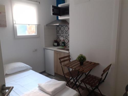 a room with a table and chairs and a kitchen at City Center Guest house in Valencia