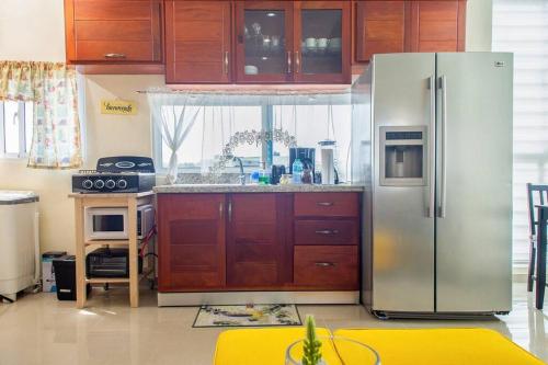 a kitchen with a stainless steel refrigerator and wooden cabinets at Maravilloso Apto en Santo Domingo in Santo Domingo