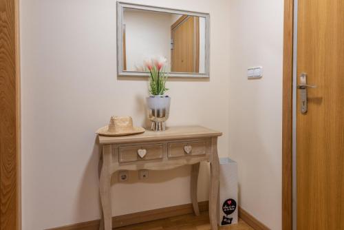 a table with a vase on it with a mirror at apartamento centro sanxenxo con parking gratis in Sanxenxo