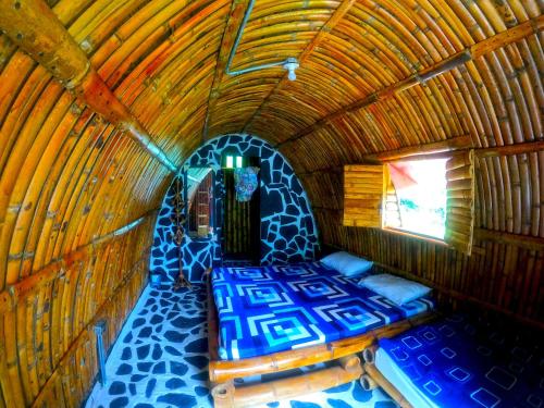 a room with a bed in a bamboo house at Termales el Escondite in Florencia