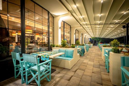 ein Restaurant mit blauen Stühlen und Tischen in einem Gebäude in der Unterkunft Hotel Ub Aqua Park in Ub