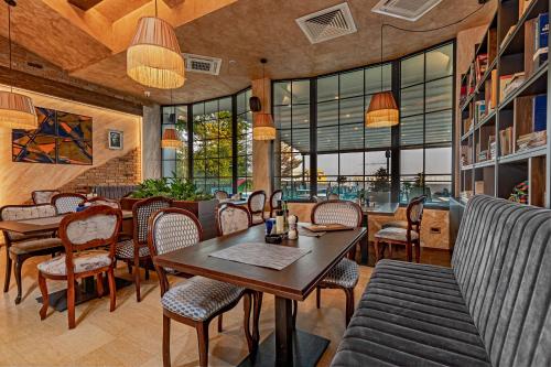 a restaurant with a table and chairs and windows at Hotel Ub Aqua Park in Ub