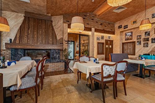 a dining room with tables and a fireplace at Hotel Ub Aqua Park in Ub