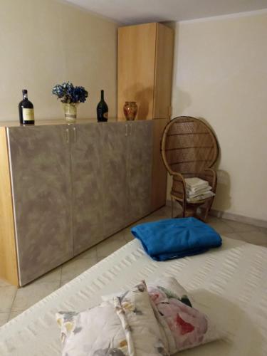Cama en habitación con armario y silla en " La casa di Elena " en Pietrasanta