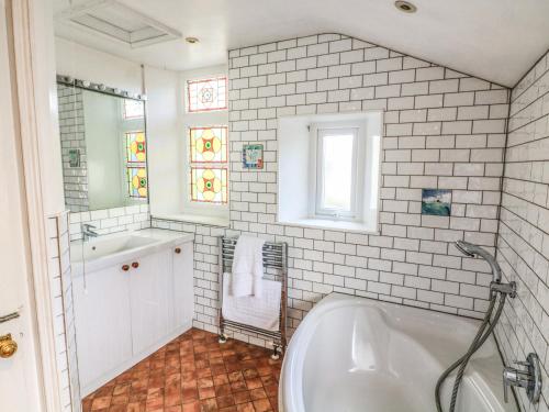 a white bathroom with a tub and a sink at Victoria Lodge in Kingsbridge