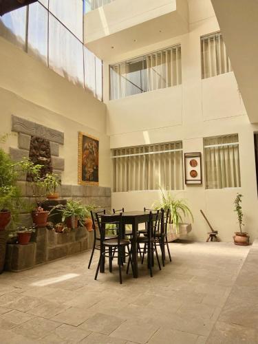 un tavolo e delle sedie in una stanza con delle piante di Hostal Casona Arrambide a Cuzco