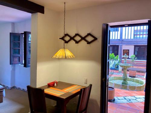 a dining room with a table and a yellow light at Casa Aranjuez in Bogotá