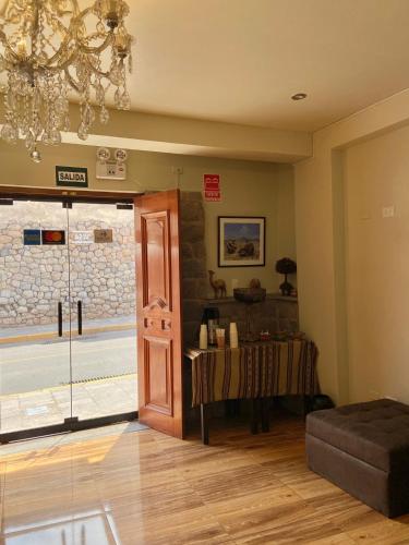 una stanza con un lampadario e una porta con un tavolo di Hostal Casona Arrambide a Cuzco