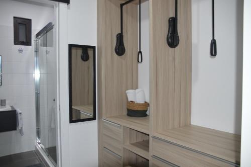 een badkamer met een douche en een houten kast met handdoeken bij Cozy Stays Cayala Apartments 7 in Guatemala