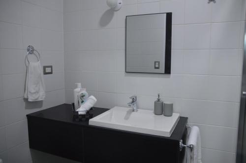 a bathroom with a white sink and a mirror at Cozy Stays Cayala Apartments 7 in Guatemala