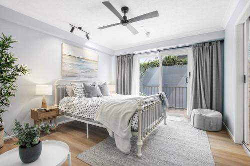 a bedroom with a bed with a ceiling fan at Canberra Heights Unit 2 35 Canberra Tce Kings Beach in Caloundra