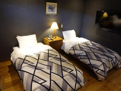 two beds sitting next to each other in a room at Oimatsuen in Saku