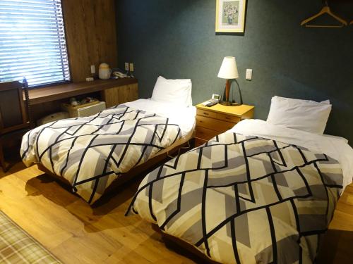 two beds sitting next to each other in a bedroom at Oimatsuen in Saku