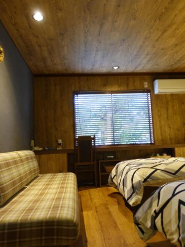 a bedroom with two beds and a window at Oimatsuen in Saku