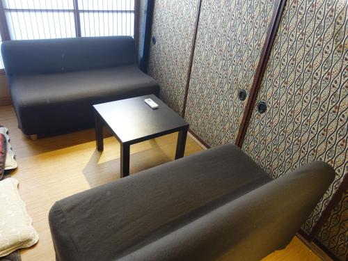 a room with a couch and a table and a chair at Oimatsuen in Saku